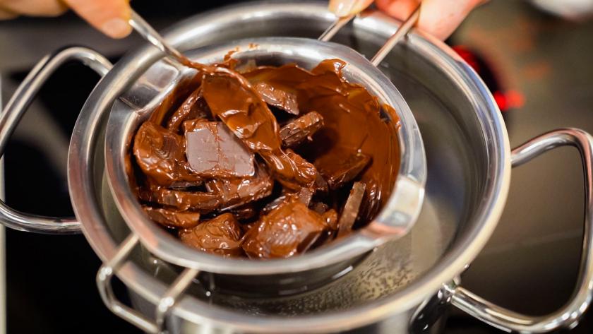 Zartbitterkuvertüre wird über einem Wasserbad geschmolzen.