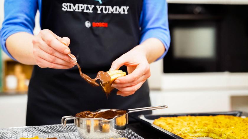 Nussecken mit Marzipan werden mit Schokolade verziert.