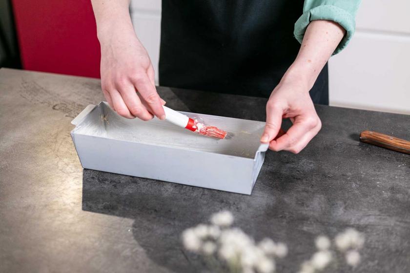 Eine Kastenform wird eingefettet.