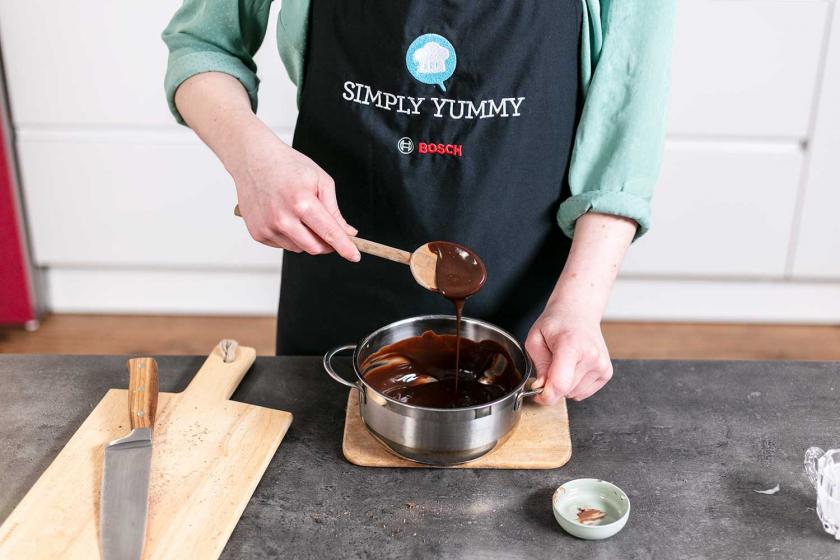 Ganache wird vom Herd genommen und verrührt.