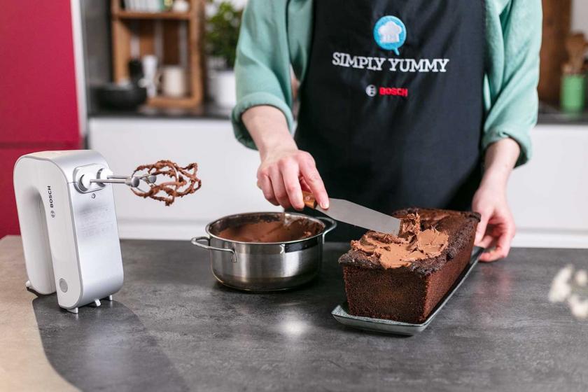 Der Nutella-Kuchen mit Schmand wird mit Ganache eingestrichen.