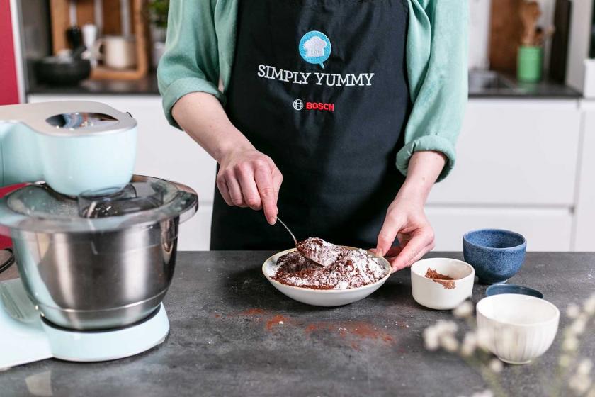 Mehl und Kakao werden auf einem Teller vermischt.