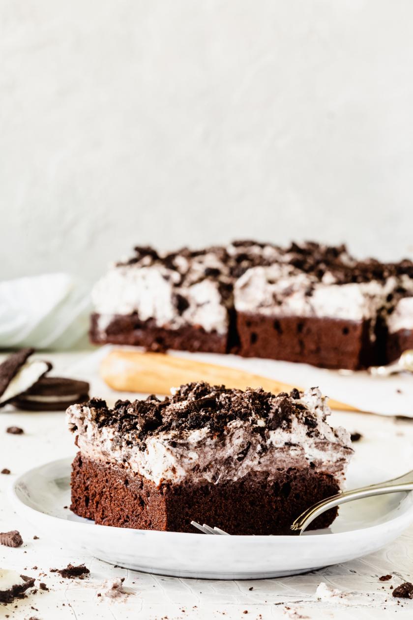 Ein Stück Oreo-Kuchen vom Blech auf einem Teller mit angelegter Gabel.