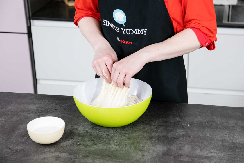 Der Ciabatta Teig wird vorsichtig in einer Schüssel zusammengelegt.