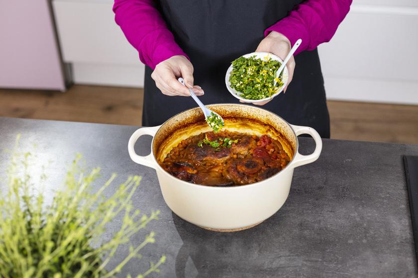 Gremolata wird über dem Ossobuco verteilt.