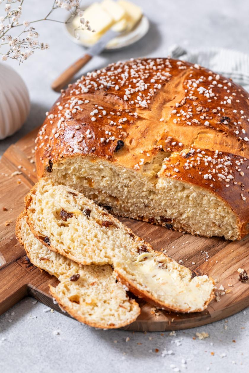 Osterbrot angeschnitten auf einem Holzbrett auf einem Tisch