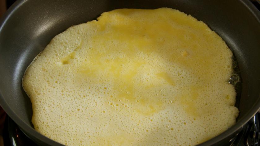 Pfannkuchen werden in einer Pfanne ausgebacken.