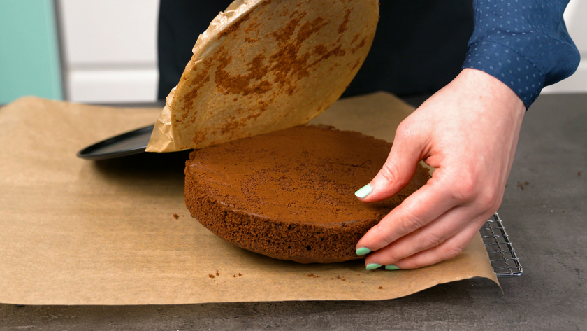 Die Böden für den Piñata Kuchen kühlen auf einem Gitter mit Backpapier aus.
