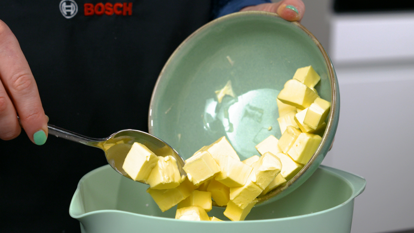 Weiche Butter für die Creme des Piñata Kuchens wird in eine Schüssel gefüllt.