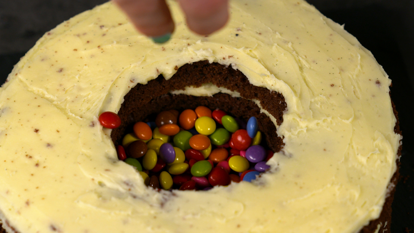 Der Piñata Kuchen wird mit Schokolinsen gefüllt.