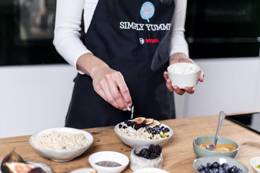 Das Porridge in einer Schüssel wird mit Kokoschips garniert.