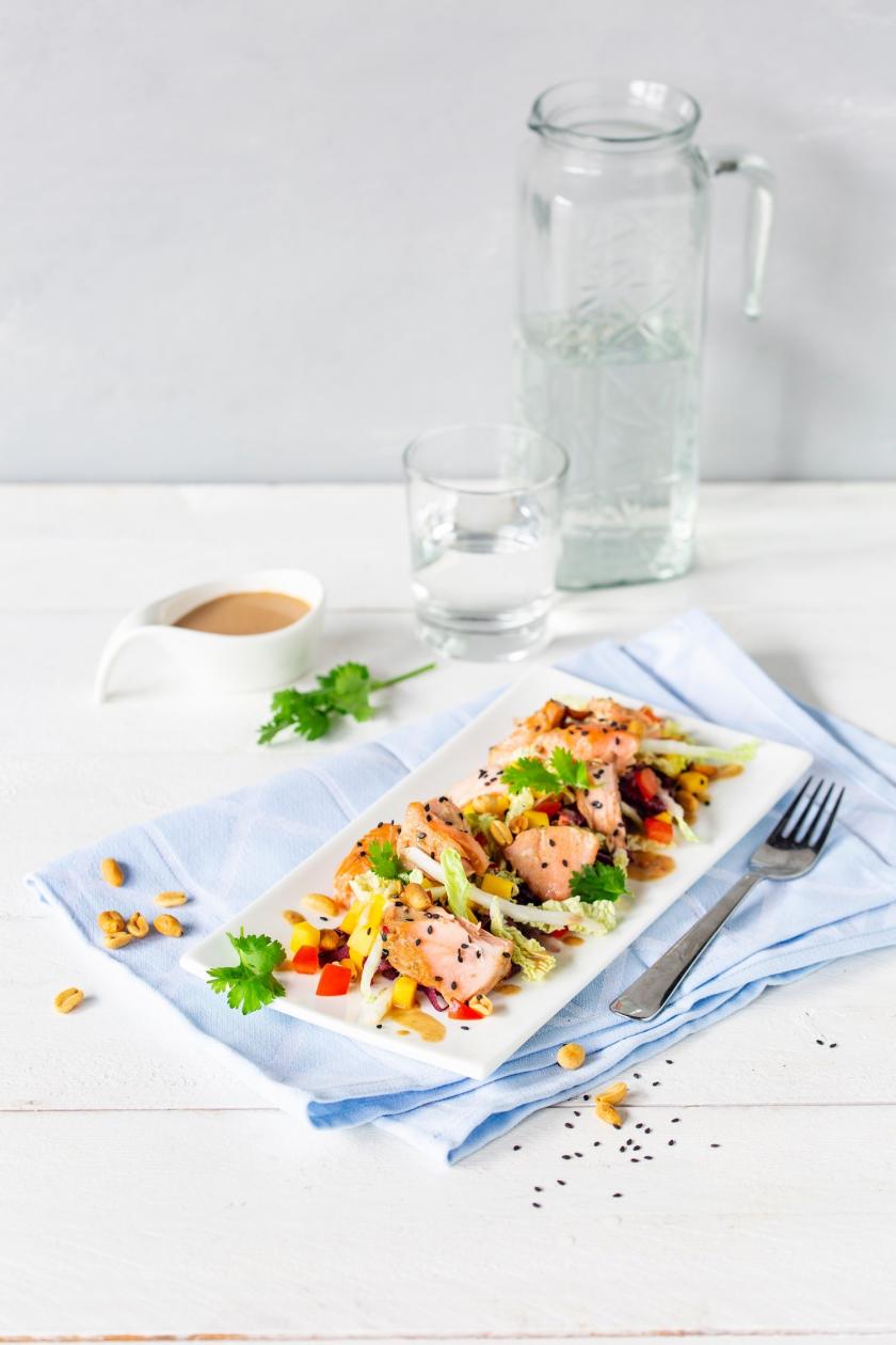 Weiße Platte mit Pulled Lachs Salat angerichtet.