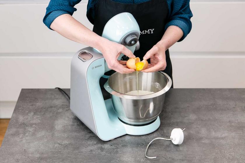 Ei zu den trockenen Zutaten des Quark-Öl-Teigs geben.