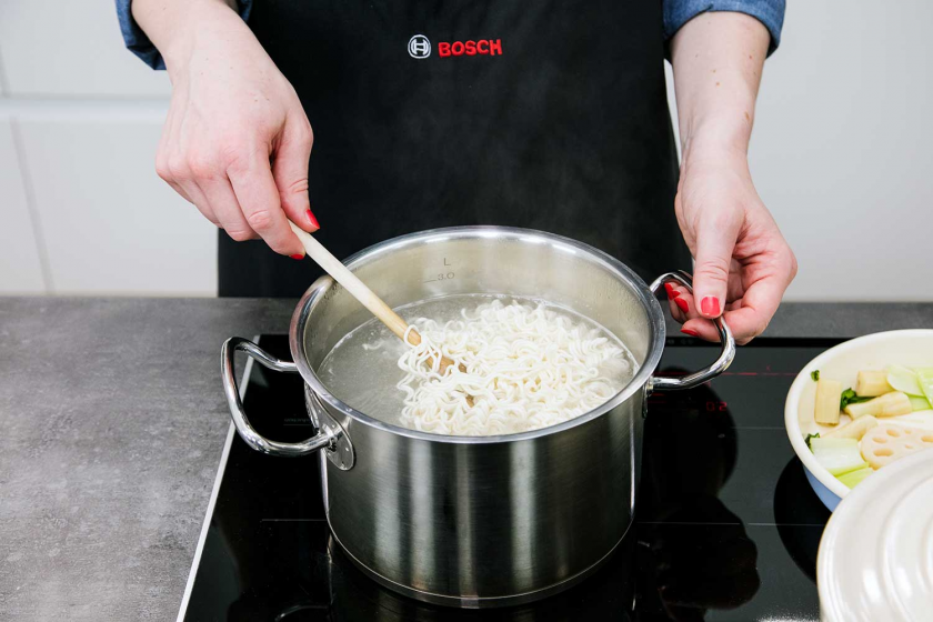 Ramen werden in einem Topf gekocht.