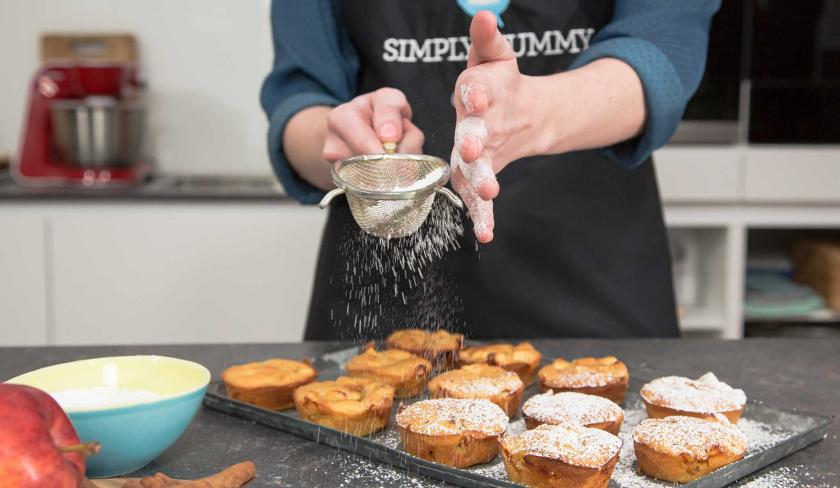 Puderzucker wird über die Apfel-Zimt-Muffins gestäubt.