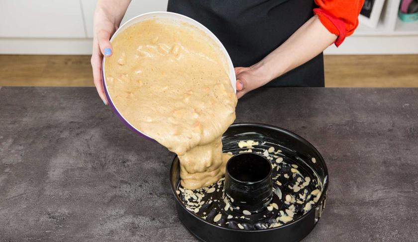 Der Teig für den Apfelkuchen mit Buttermilch wird in die Backform gegeben.