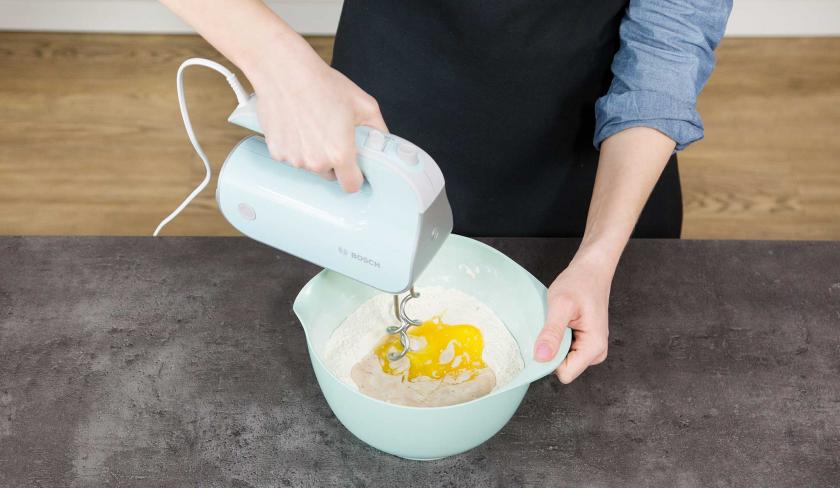 In einer Schüssel wird der Teig für den Kirsch-Streuselkuchen mit einem Mixer verrührt.