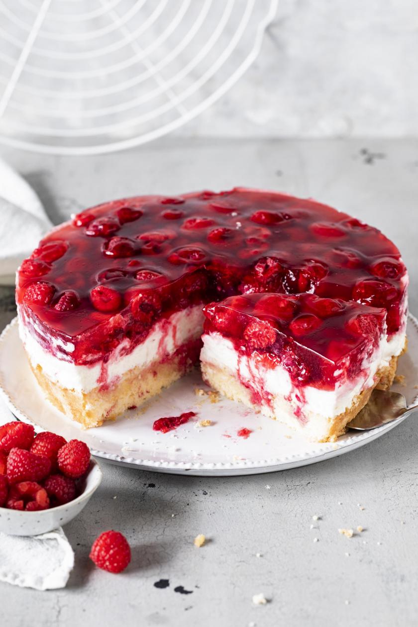 Himbeer-Joghurt-Torte angeschnitten auf einer Tortenplatte