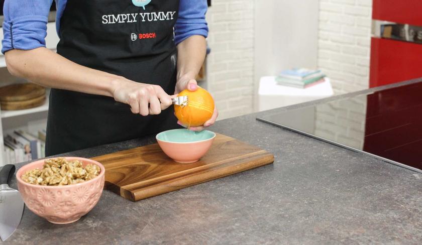 Für den Boden des Apfel-Walnuss-Kuchen werden Zesten einer Orange abgeschnitten.