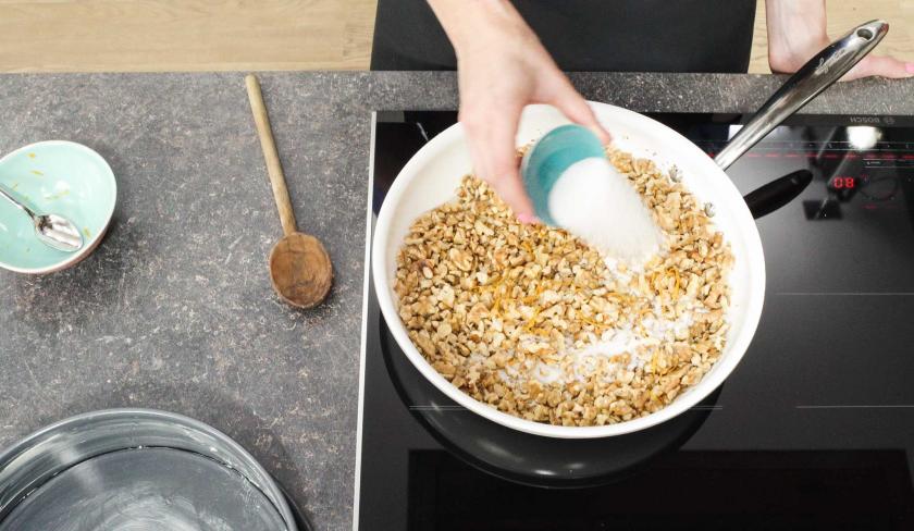 Für den Apfel-Walnuss-Kuchen werden Nüsse in einer Pfanne mit Zucker karamellisiert.