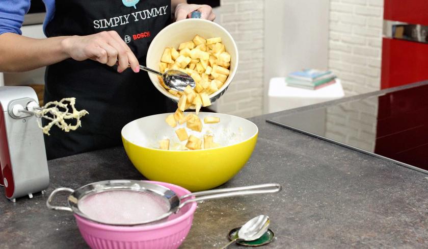 Für den Apfel-Walnuss-Kuchen werden geschnittene Äpfel in den Teig eingerührt.