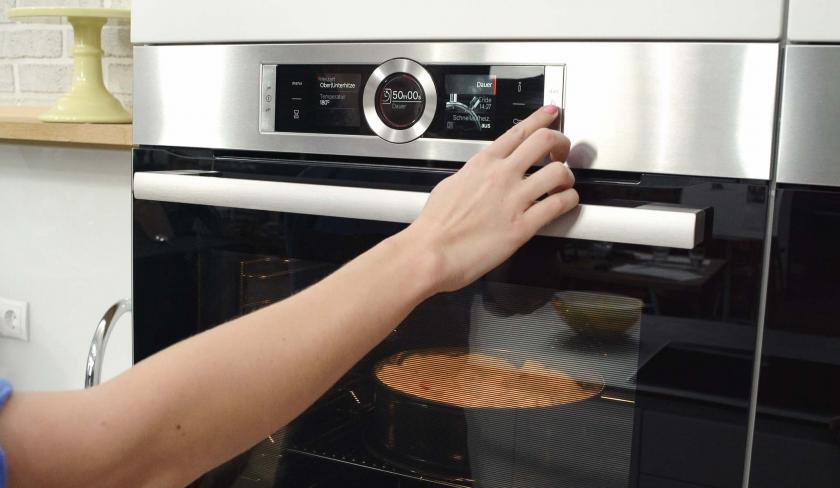 Der Apfel-Walnuss-Kuchen ist im Backofen. Letzterer wird eingestellt.