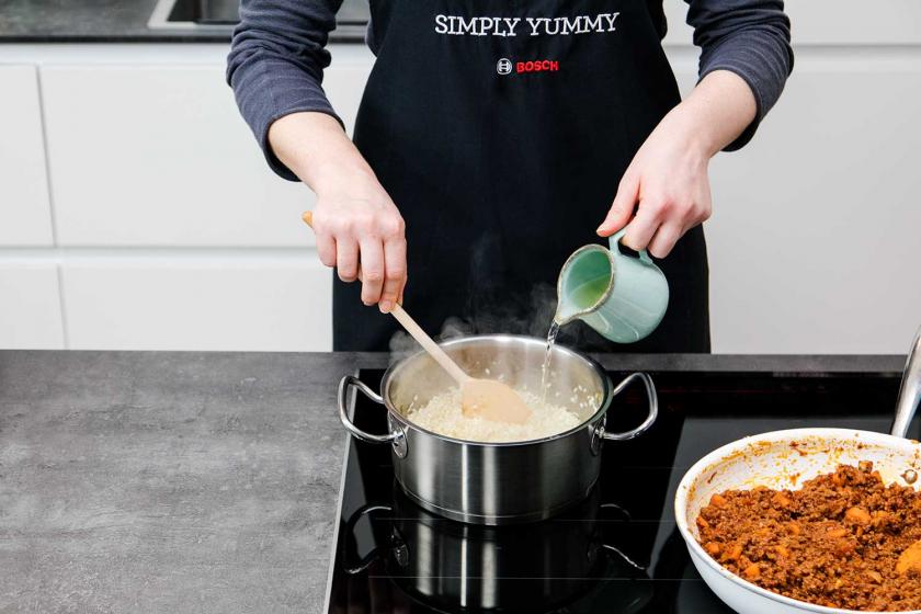 Zum Risotto für die Arancini wird Wein gegossen.