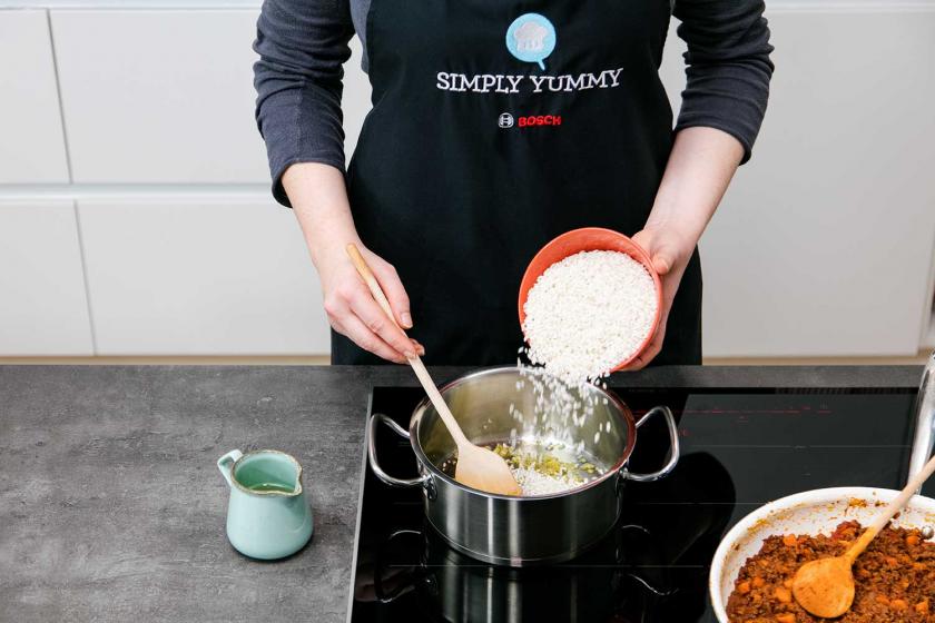 Für das Risotto für die Arancini wird Reis in einen Topf gegeben.