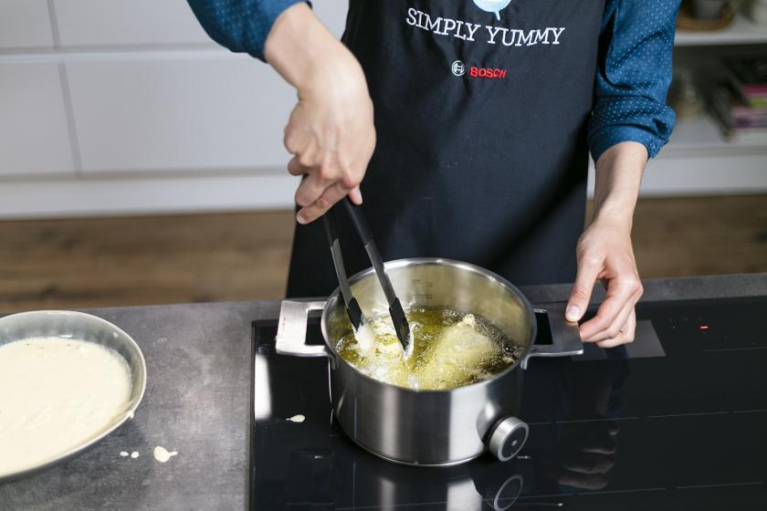 Backfisch wird in einem Topf in heißem Fett frittiert.