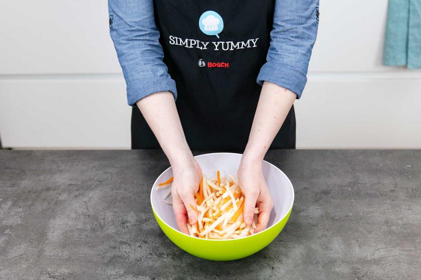 Für Bánh mì werden Rettich und Möhre in einer Schüssel vermengt.