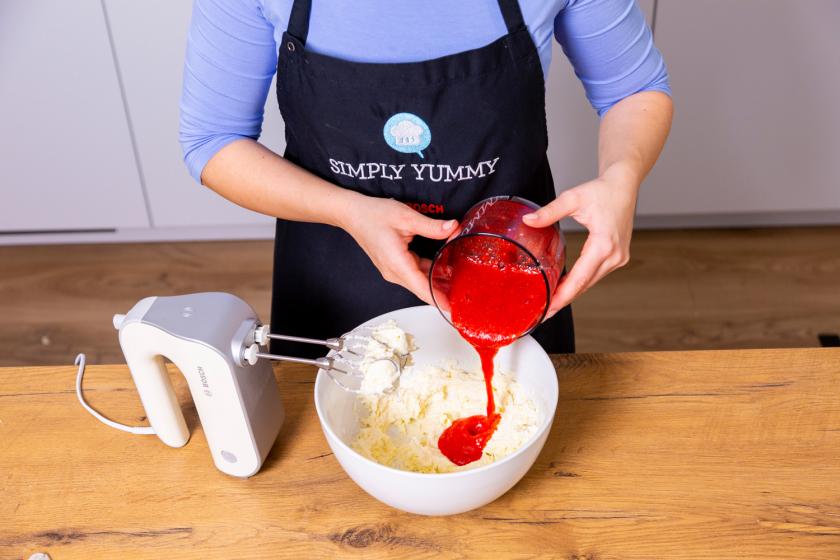 Erdbeerpüree wird zur Quarkcreme in eine Schüssel gegeben.