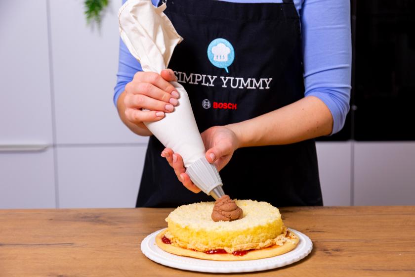 Schokosahne wird auf den Boden für die Benjamin Blümchen Torte gspritzt.