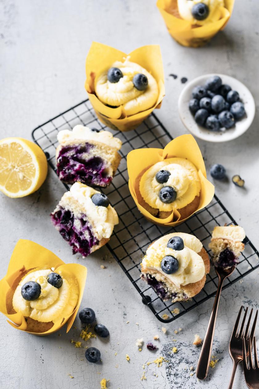 Zitronen-Cupcakes mit Blaubeeren auf einem Kuchengitter