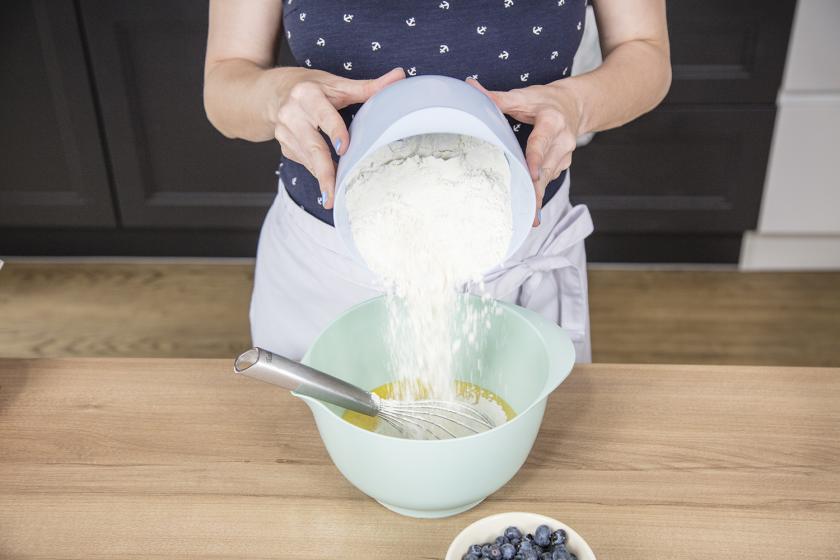 Für die Blaubeermuffins wird Mehl zu den flüssigen Zutaten gegeben.