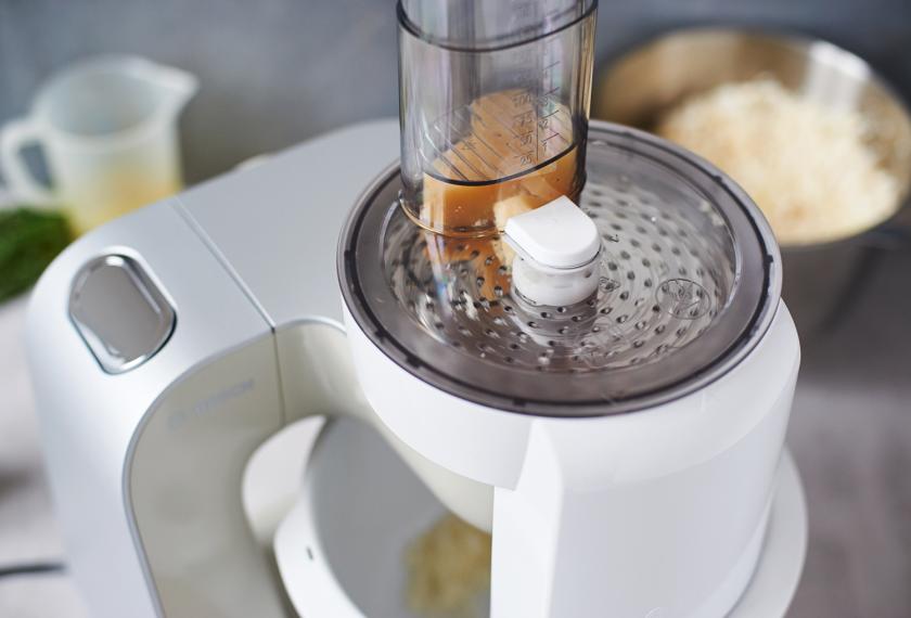 Parmesan für das Blumenkohl Risotto wird in einer Küchenmaschine gerieben.