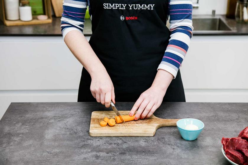 Für Boeuf Bourguignon werden Möhren geschnitten.