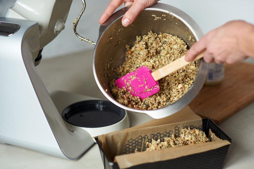 Die Mischung für das Brot ohne Mehl wird in eine Kastenform gefüllt.