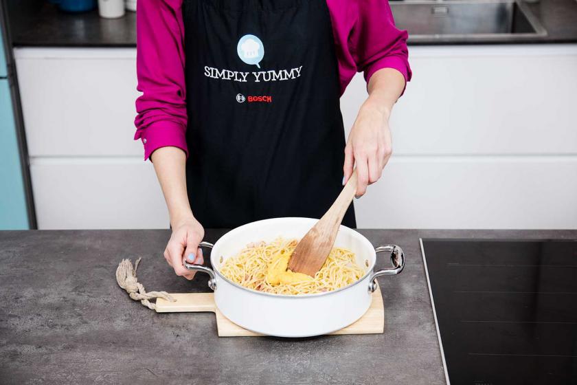 Für die Carbonara werden Spaghetti mit Ei-Käse-Mischung verrührt.