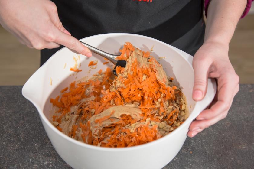 Karotten unter den Rührteig für Carrot Cake heben.