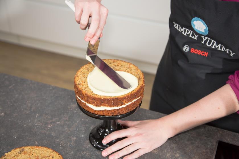 Zwei Carrot Cake Böden übereinander mit Frosting bestrichen.
