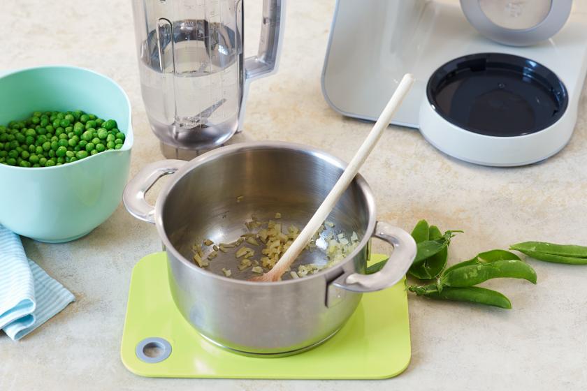 Für Erbsencremesuppe wird eine Zwiebel in einem Topf angebraten.