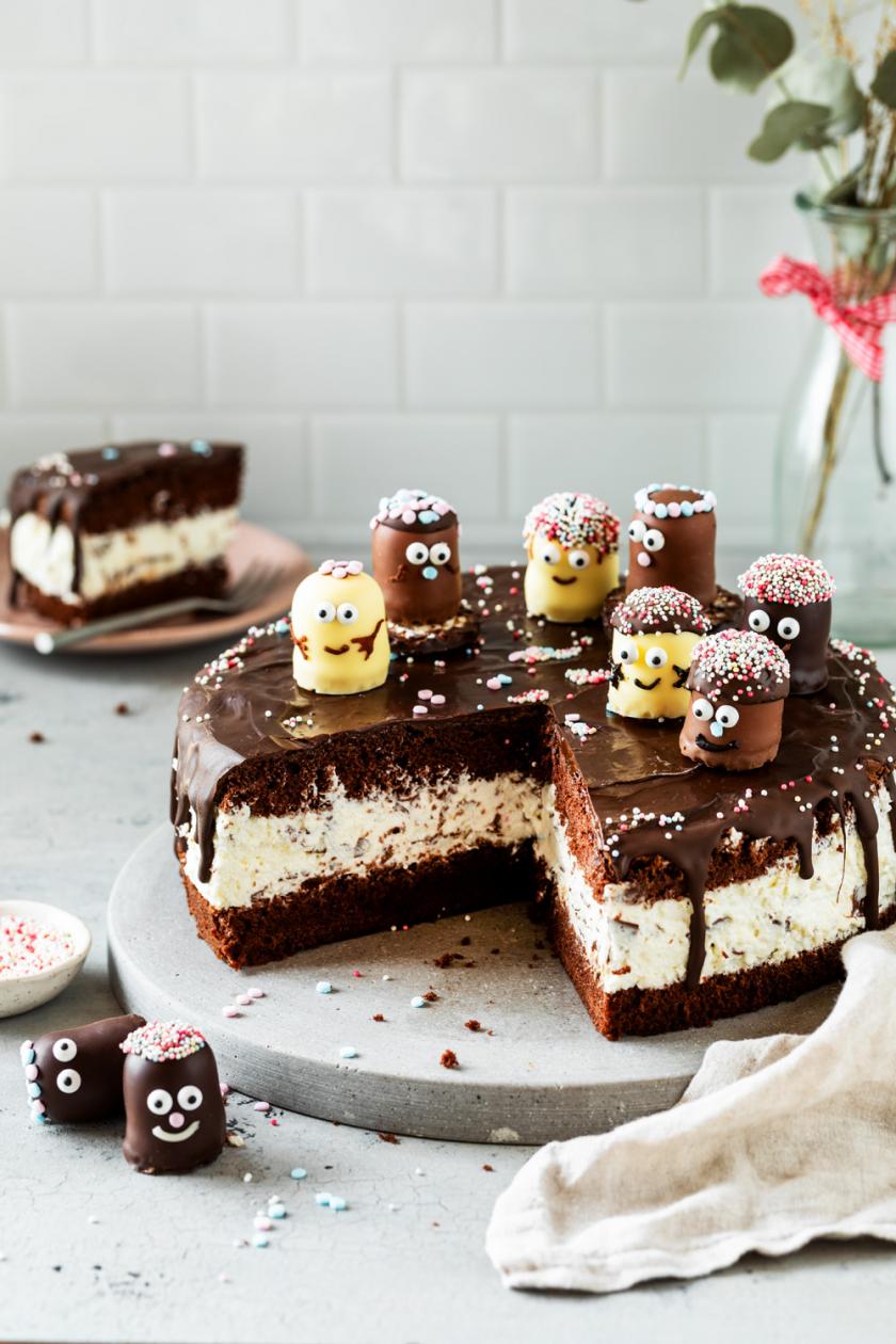 Angeschnittene dekorierte Geburtstagstorte, Schokoladendrip läuft am Rand herunter