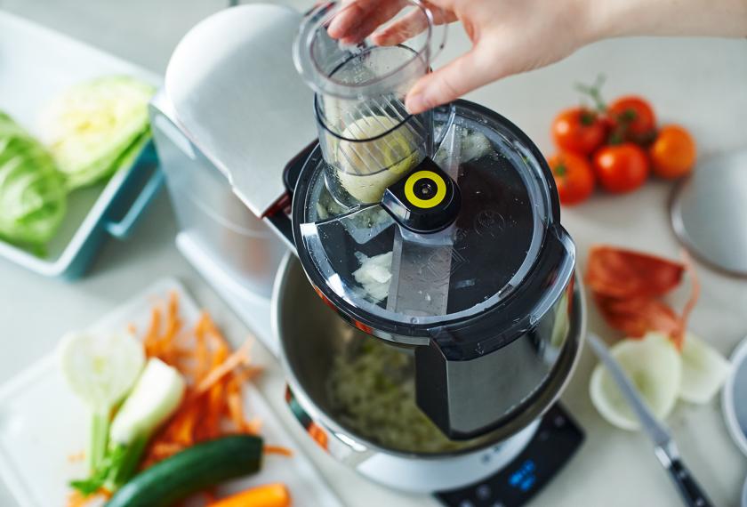 Gemüse für Gemüselasagne vegetarisch wird mit einer Küchenmaschine geschnitten.