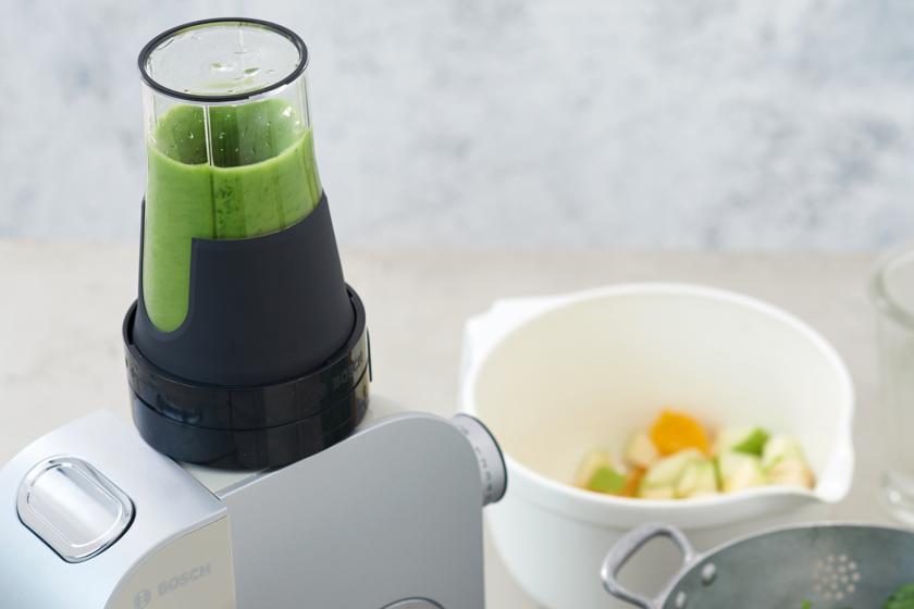Ein grüner Smoothie wird in einem Mixer püriert.