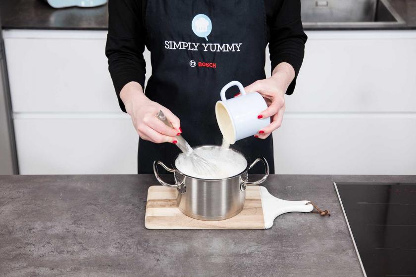 Grießbrei wird in kochende Milch geschüttet.