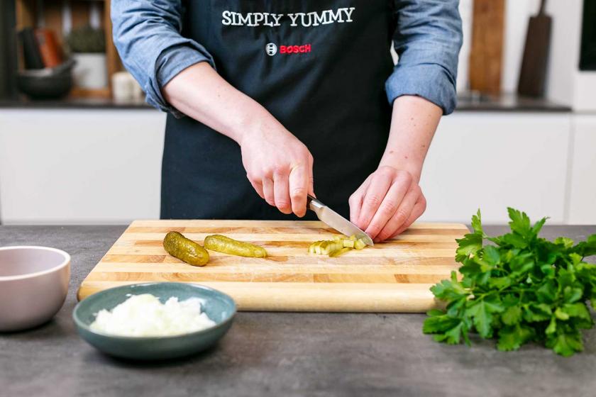 Gewürzgurken werden gewürfelt.