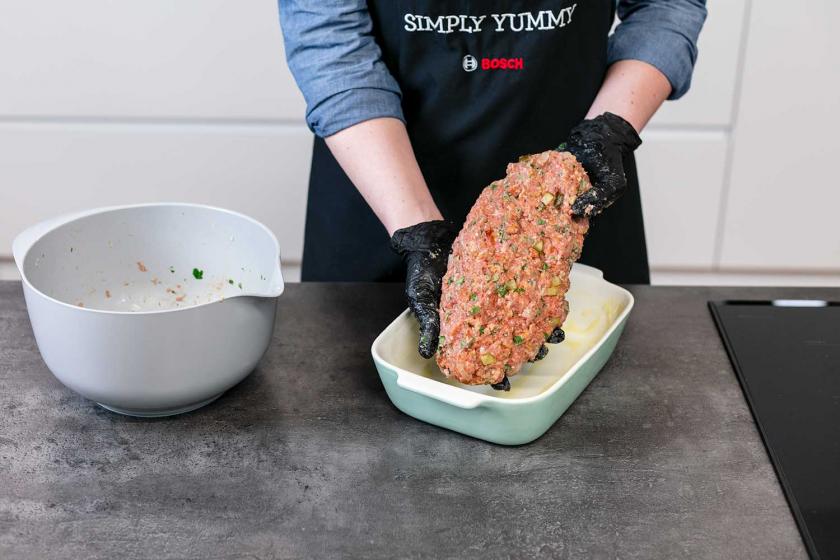 Der Hackbraten wird in eine Auflaufform gegeben.