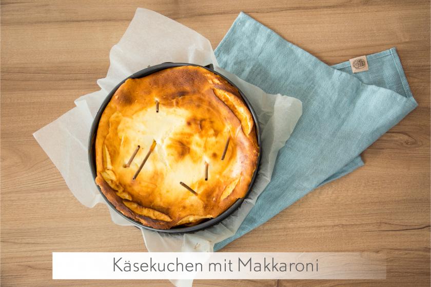Ganzer Käsekuchen ohne Boden mit Makkaroni in der Creme auf einem Tuch.