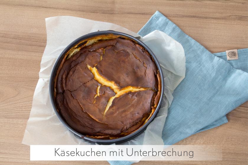 Ganzer Käsekuchen ohne Boden steht in der Form auf einem blauen Tuch.