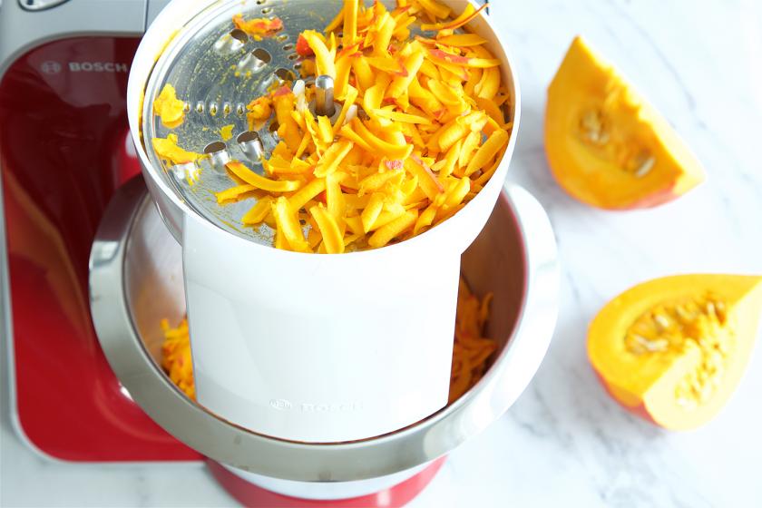 Für die Kürbispuffer wird Hokkaido in einer Küchenmaschine geraspelt.